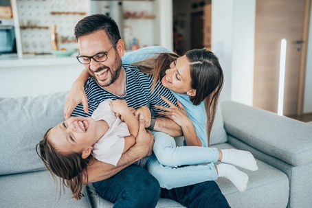 family hugging on sofa